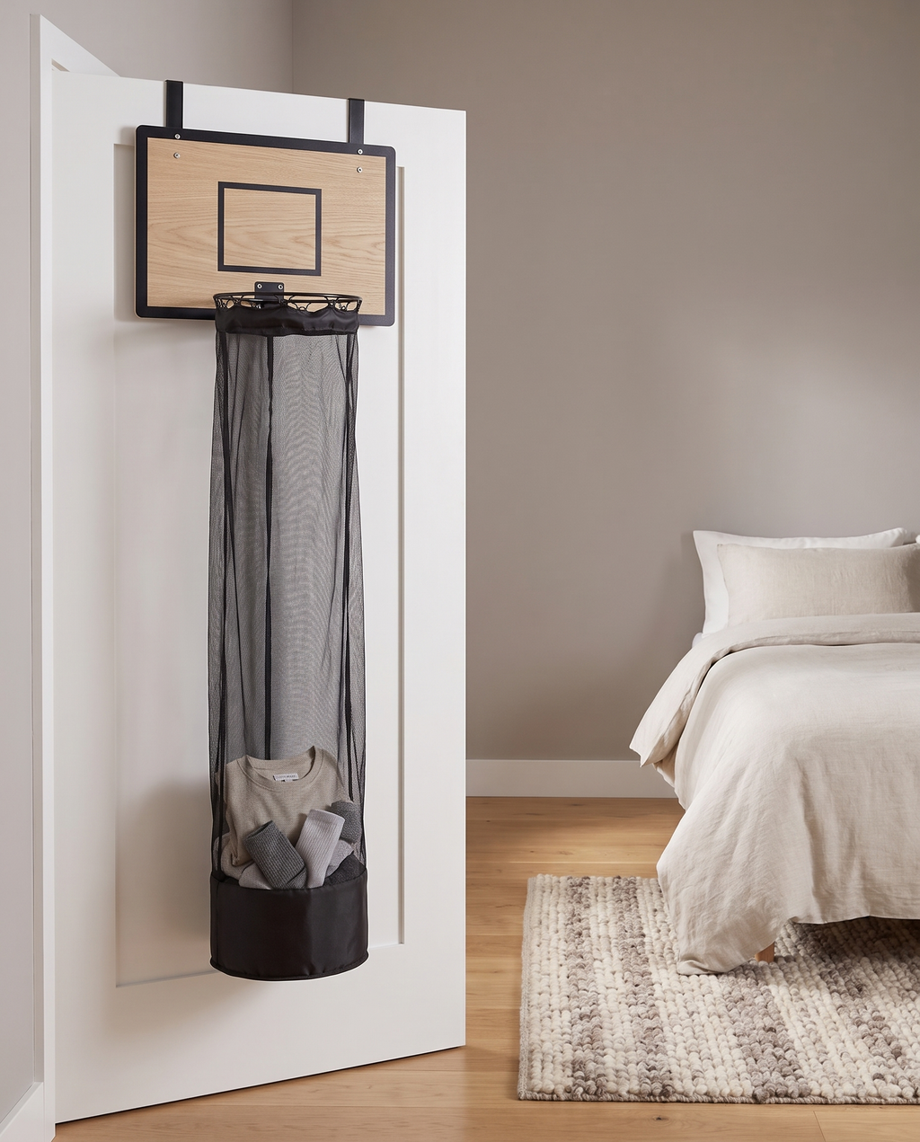 Hoop Laundry Hamper in a calm bedroom with rolled socks in the net